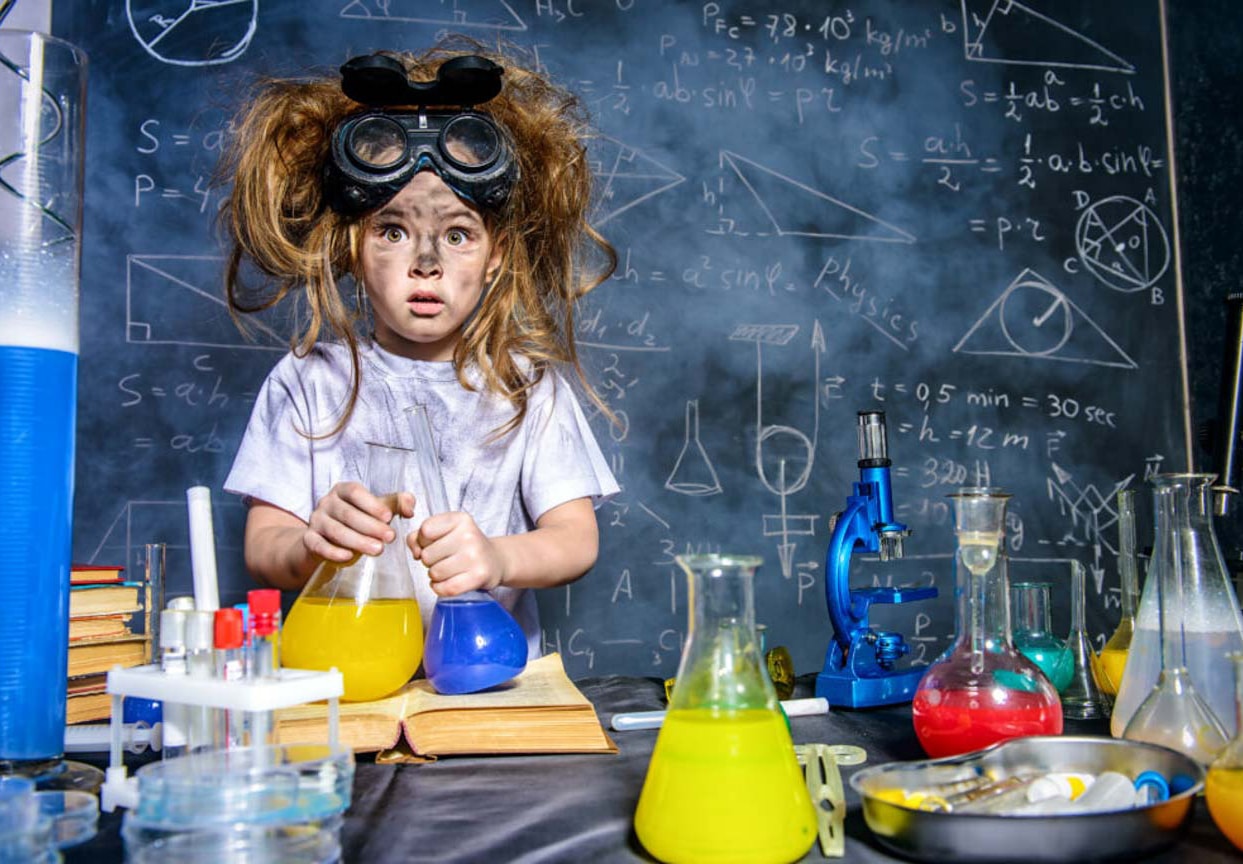 Little girl with crazy hair and goggles in a lab